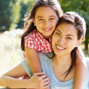 girl leaning over shoulders of woman